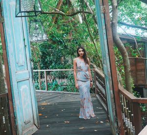 Young woman standing against tree