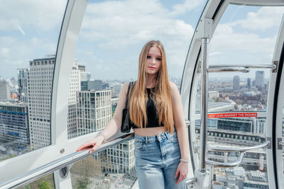 Portrait of young woman standing in city