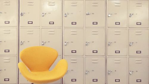 Yellow chair against lockers