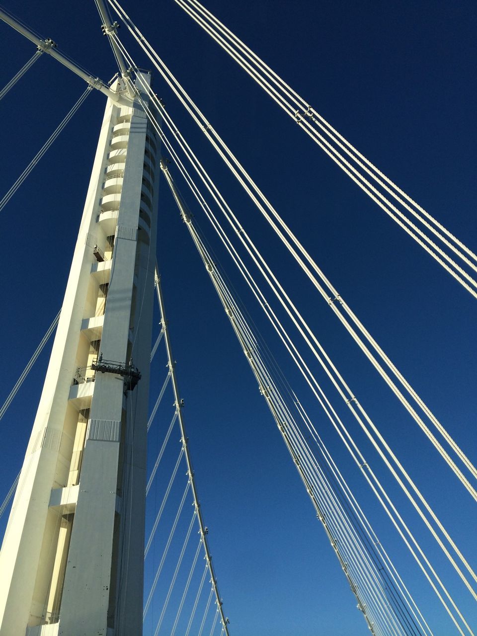 connection, low angle view, bridge - man made structure, engineering, suspension bridge, clear sky, transportation, blue, built structure, architecture, cable-stayed bridge, bridge, cable, copy space, steel cable, travel, outdoors, travel destinations, sky, no people