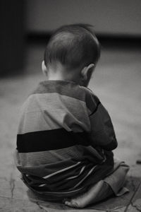 Eye level angle view of boy sitting on the floor