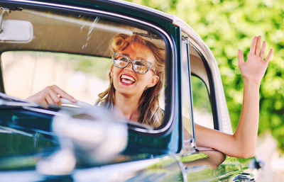 Smiling woman driving vintage car