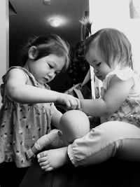 Close-up of girl holding baby sitting