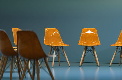 Close-up of empty chairs on table against wall