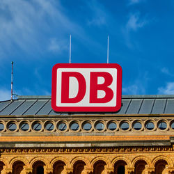 Low angle view of sign against blue sky