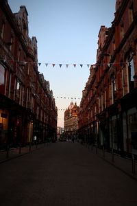 Street amidst buildings against sky in city