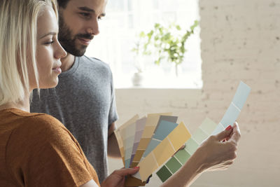 Young couple in a loft looking at color samples