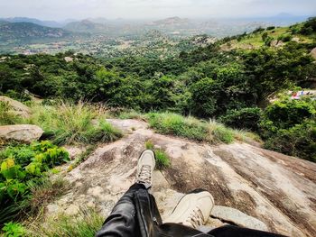 Low section of person on road amidst trees