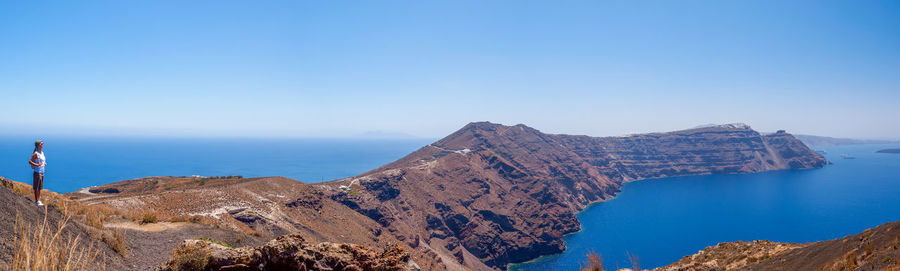 Woman on hiking trail on santorini island. panorama view. hiking on the island. cyclades, greece