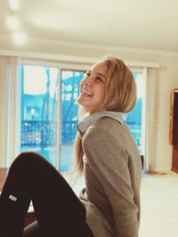 Smiling young woman sitting at home