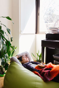 Woman relaxing on bean bag at home