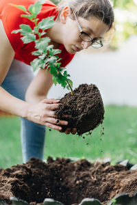 Midsection of woman holding plant