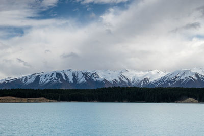 A scenic landscape of new zealand southern alps and lake pukaki with blue sky and clouds.