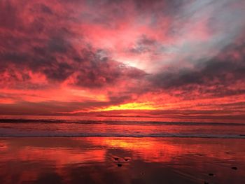 Scenic view of sea against dramatic sky during sunset