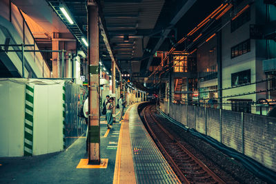 Train at railroad station platform at night