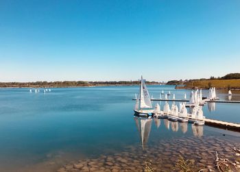 Scenic view of lake against clear blue sky