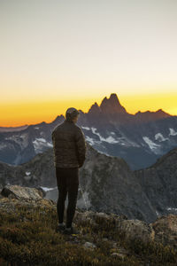 Rear view of woman standing on mountain against sky