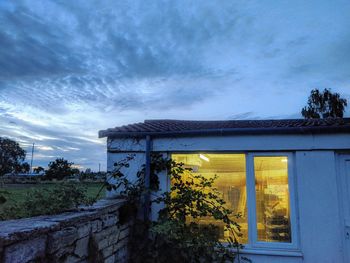 House by building against sky at sunset