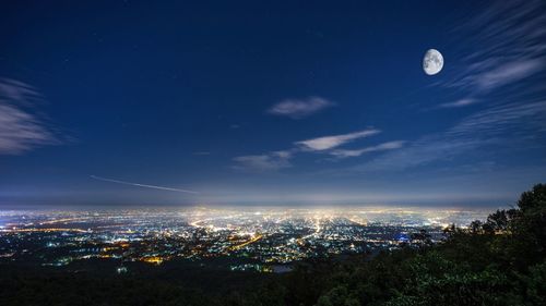 Aerial view of illuminated city against sky at night