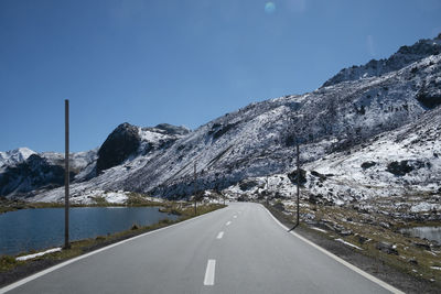 Road by mountain against clear blue sky