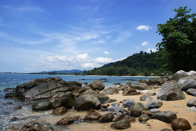 Rocks by sea against sky