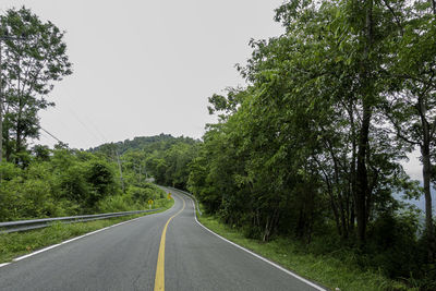 Countryside road passing through the lush green tropical rain forest mountain landscape