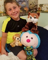 Portrait of cute boy with toy at home