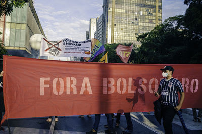 People on street against city