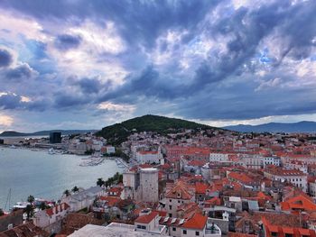 View of cityscape against cloudy sky