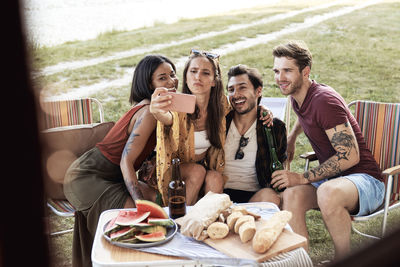 Portrait of smiling friends sitting on table