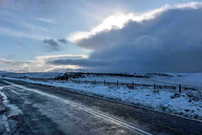 Snow covered road against sky