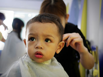 Barber cutting boy hair at salon