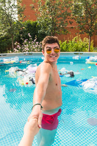 Portrait of smiling young man in swimming pool