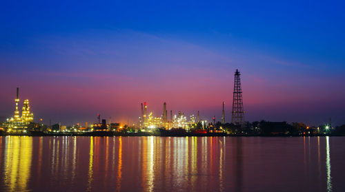 Illuminated factory against sky at night