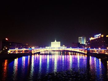 Illuminated bridge over river at night