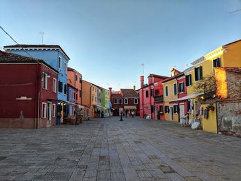 Footpath amidst buildings against sky