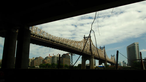 Low angle view of bridge and buildings against sky