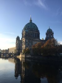 Berlin cathedral by river against blue sky