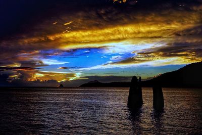 Scenic view of sea against dramatic sky during sunset