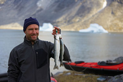 Man holding up fresh arctic char in greenland