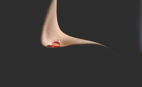 Close-up of woman hand over black background