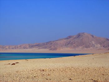 Scenic view of beach against clear blue sky