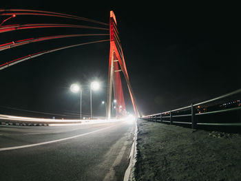 Light trails on bridge over road at night
