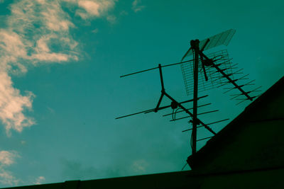 Low angle view of silhouette windmill against sky