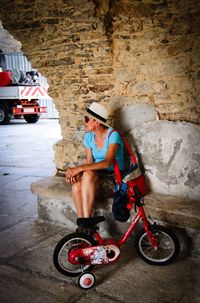 Full length of boy sitting on wall