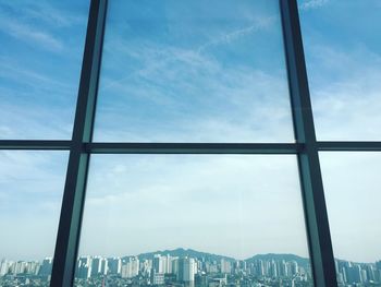 Close-up of cityscape against sky seen through window