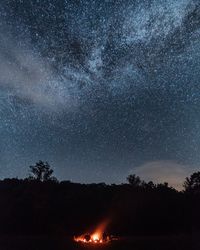 Bonfire against stars in sky at night