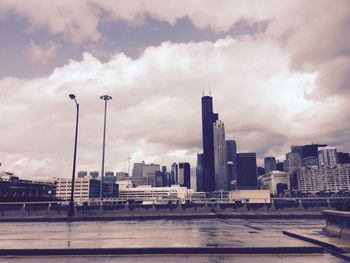 Modern buildings by street against sky