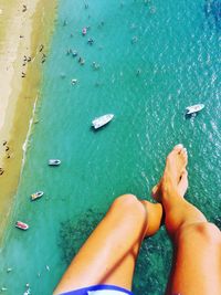 Low section of person paragliding over sea