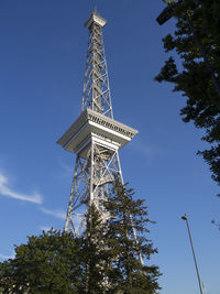 Low angle view of communications tower against blue sky